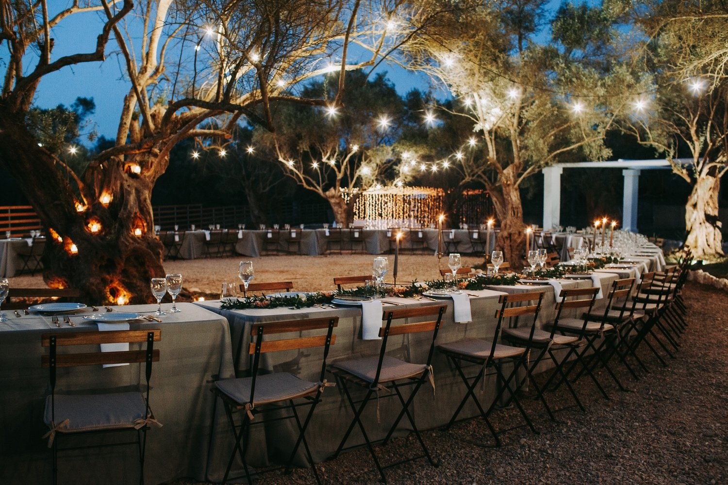 I tavoli e le luci del giardino di Eleonas, tra gli ulivi di Lefkada